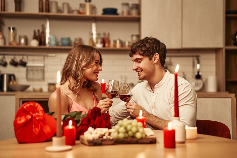 Casal jantando em uma mesa com decoração para o Dia dos Namorados